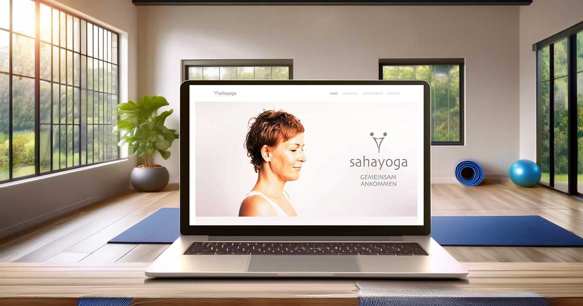 Aufgeklappter Bildschirm mit Ansicht Website sahayoga - im Hintergrund verschwommen ein Yogastudio